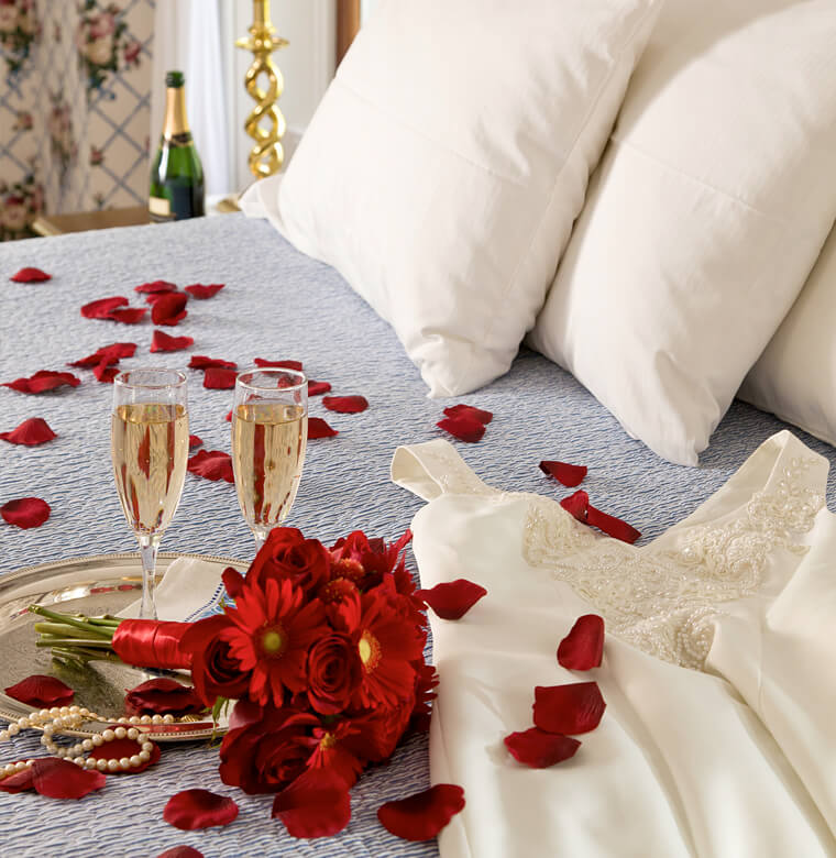 romance with red flowers and Champagne on bed